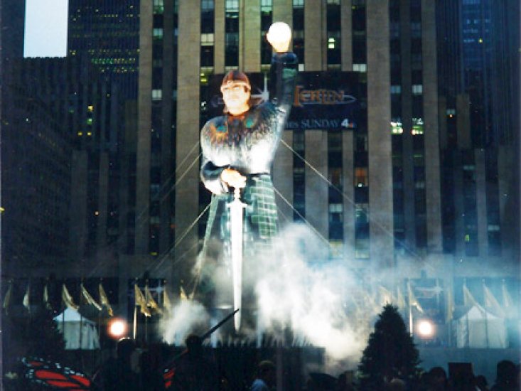 100â€™ tall Merlin standing in Rock Center